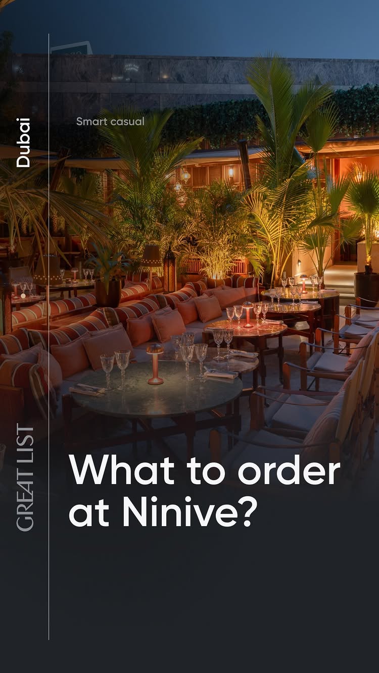 An outdoor dining scene at night shows tables with glasses and candles, arranged for diners, set among lush greenery. The composition is formal, stylish setting with a text overlay.