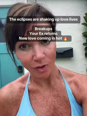 A woman with light brown hair and fair skin is shown in a selfie-style shot. The background is lightly blurred, showing a door and a mailbox. The woman is wearing a blue top. The text overlayed on the top, center of the video, is in white font with a black border.