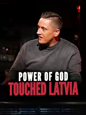 A man with short, styled hair is centered, looking slightly to his left. The background is dark. Text overlays across the bottom, in a bold font, reads: POWER OF GOD TOUCHED LATVIA.