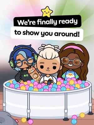 The image features three animated characters, reminiscent of a cartoon or game style. They sit in a large, round pool filled with colorful balls. Above them, on a gradient background of pink and yellow, is a black banner with the white text "We're finally ready to show you around!". A star icon is positioned above the banner. The characters have distinct hair styles, glasses, and clothing, and one holds a beverage.