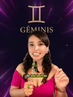 A woman is speaking in front of a digitally created background. The background transitions from purple to a darker color. The woman is wearing a pink top and holding a staff. The background contains the Gemini symbol and the word "GÉMINIS". The woman is clearly the central focus, with a warm and inviting expression.