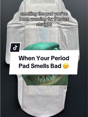 The image features a white sanitary pad with text overlays. Centered within the pad is a green, organic-looking shape, seemingly representing the contents of the pad. Above the pad, text reads, 'smelling the pad you've been wearing for 5 hours straight.' Below, a white banner displays, 'When Your Period Pad Smells Bad' with a smiley face emoji. A TikTok logo is in the top left.
