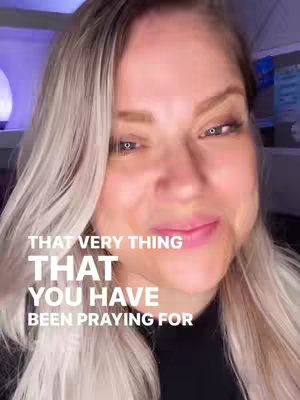 A close-up shot of a woman with blonde hair, slightly smiling directly at the camera. The background has a blurred, cool-toned interior, with overlaid text in a bold, white font at the bottom third of the image.