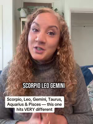 A woman with curly blonde hair is centered in the frame, looking directly at the camera and talking. Text overlays are positioned below her, and the background is a softly lit interior.