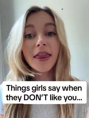 A woman with long blonde hair looks towards the camera with her tongue out and text overlayed in a white box at the bottom.