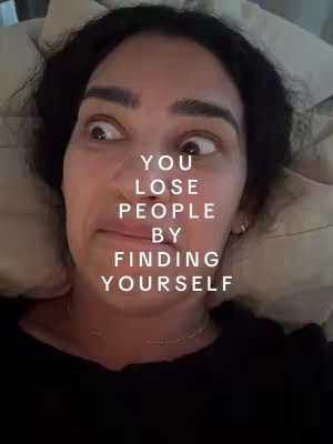 A close-up shot of a woman lying in a bed with her eyes wide and looking up and left. Text in a white, modern font is superimposed on the image.