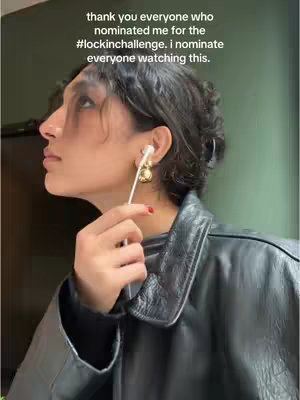 A woman in a leather jacket looks up, holding the wire of an earbud. Text overlays on the top third of the frame.