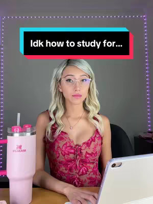 A woman with blonde hair sits at a desk with a pink Stanley cup and a tablet, a text overlay at the top reads: "idk how to study for...". The room is dimly lit with a purple LED light.