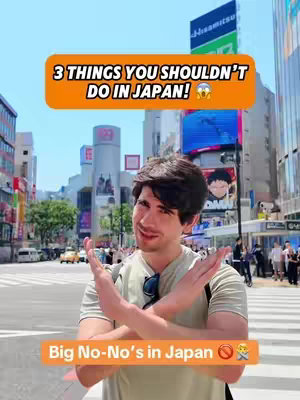 A man in front of a busy street in Japan. He's wearing a light green shirt and sunglasses on his shirt collar, with both arms in front of him in an "X" gesture. There are two text boxes: one filled with orange color, has white text across the top and says, "3 THINGS YOU SHOULDN'T DO IN JAPAN!" and then the other has orange color with white words "Big No-No's in Japan" at the bottom of the image.