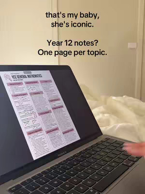A person is using a laptop in a bedroom setting. The laptop screen displays a study guide titled 'VCE General Mathematics.' White sheets are visible behind the laptop.