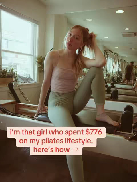A young woman with light skin and fair hair sits on a pilates machine in a bright, airy studio, looking towards the camera. She wears a rose-colored crop top and sage green leggings. A text overlay provides a hook.