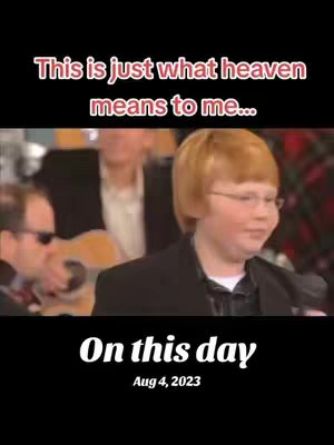 The cover image shows a split screen with a video scene at the top and a black background at the bottom. The video scene features a young man with red hair and glasses singing into a microphone, positioned center-right. Behind him are other musicians. At the bottom, a black bar displays white text: "On this day" with the date "Aug 4, 2023" below.