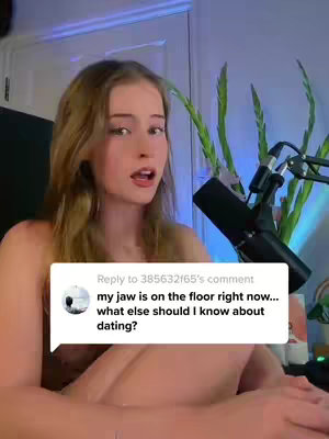 The cover image features a young woman with long brown hair, sitting in front of a microphone. She is looking at the camera with a slightly surprised expression. A comment box is overlaid on the image, containing the text 'my jaw is on the floor right now... what else should I know about dating?'. The background includes a plant and some other items, with a blue light adding to the ambiance.