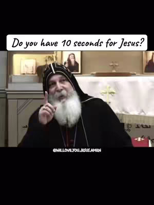 A man in a clerical robe with a long white beard and black headwear is shown addressing the camera. He is pointing his index finger upwards. Text overlayed at the top that asks: 'Do you have 10 seconds for Jesus?' The background shows a glimpse of what appears to be a church setting.