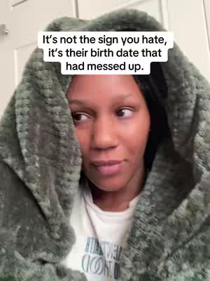A woman with dark hair is shown from the chest up, wrapped in a plush, hooded gray blanket. She's looking slightly to the side with a thoughtful expression. Above her head, a white text overlay provides context for the video.
