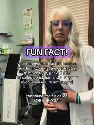 A woman with blonde hair and glasses stands in what appears to be a clinic or office setting. She is wearing a white coat. A text overlay reads 'FUN FACT!' with additional text describing peristalsis and borborygmi. Behind her, medical equipment and a sign about pain are visible.