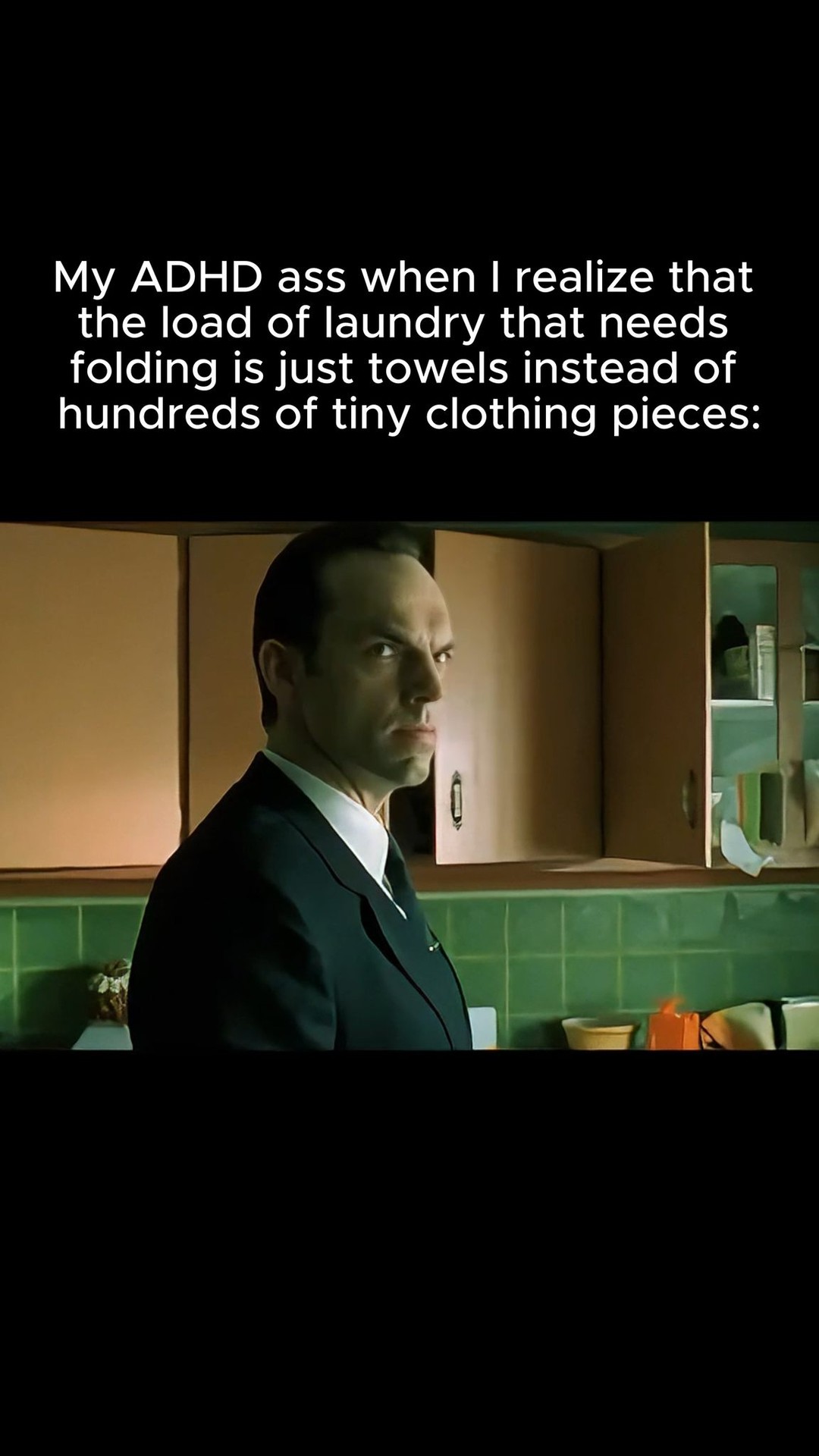 The cover image is a still from a film, featuring a man in a suit, turned to the side, looking slightly annoyed. Text overlay in white font is placed at the top of the image. The background shows the interior of a kitchen with cabinets.