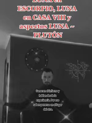 A grayscale image showing a man in a dark setting, likely indoors. He has a beard and is looking directly at the camera. Above him is overlaid text in a red-tinted font concerning astrological topics. Behind him on the wall are circular and compass-like designs.