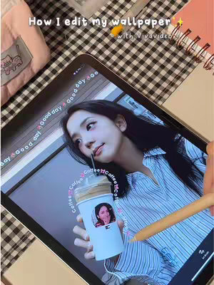 An image of a tablet displaying a woman's photo used as a wallpaper. The tablet is held in a hand over a black and white checkered surface. There's coffee, and various other objects in the scene, including a pencil and a pink pouch.