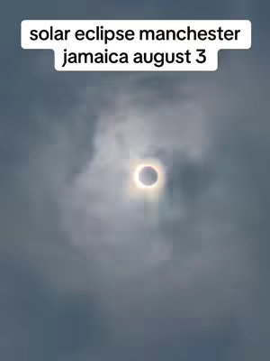 The image shows a solar eclipse with a dark circle in the center, surrounded by a bright ring. The image has a cloudy sky as a backdrop with text overlayed at the top.