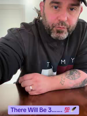 A man with a beard and a black cap is looking towards the camera. He's wearing a black sweatshirt with white lettering. A hook text is present at the bottom with a purple background.