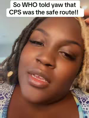 A selfie-style image featuring a close-up of a woman's face. The woman has dark skin, styled dark hair with blonde highlights, and is wearing a patterned top. Text is overlaid at the top of the image. The expression is intent.