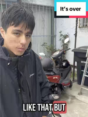 A young man stands facing the camera, with a scooter and exterior building behind him. Text overlays appear at the top and bottom of the frame.