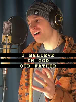 A man wearing a knit cap, headphones, and patterned jacket sings into a microphone. Text on the image reads, 'I BELIEVE IN GOD OUR FATHER.'