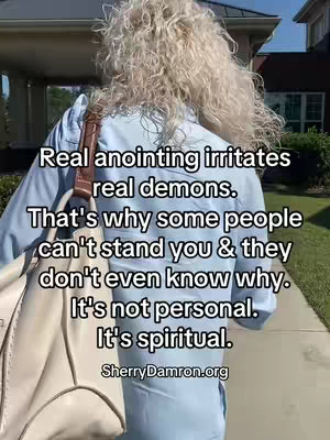 A person with blonde, curly hair is seen from the back, walking away from the camera. They are wearing a light blue button-down shirt and carrying a cream-colored purse. Overlay text in white font with a black outline fills the image, with SherryDamron.org at the bottom.