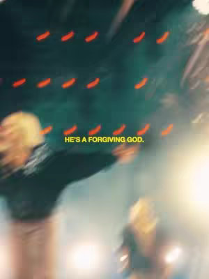 A blurry, abstract shot featuring two indistinct figures against a background with streaks of red and yellow light. Yellow text overlay states 'HE'S A FORGIVING GOD.'