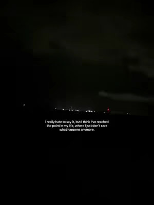 A dark, nighttime scene dominated by black and gray tones. Along the horizon, a faint suggestion of a cityscape or illuminated area is visible. The text, in white, is overlaid at the bottom, offering a sense of emotional depth.