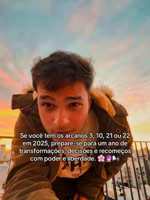 A selfie-style shot featuring a young man with dark hair, gazing toward the camera. He is wearing a brown jacket over an off-white shirt. In the background, a colorful sky suggests a sunset or sunrise. The image has text overlayed that relates to astrology and destiny.