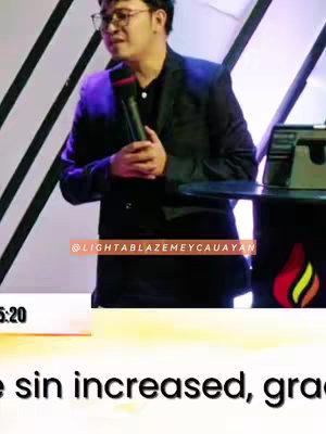 A man in a black suit is shown speaking into a microphone on a stage, with the top lighting. A pink rectangle, marked with the Instagram handle, is positioned at the top.