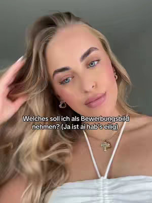 A close-up shot features a young woman with long, wavy blonde hair, gazing at the camera. She has blue eyes, rosy cheeks, and full lips. The background is indistinct, with a greyish tone. The woman wears a white top and a necklace with a pendant. Text overlayed on the image in German asks which picture she should use for her job application.