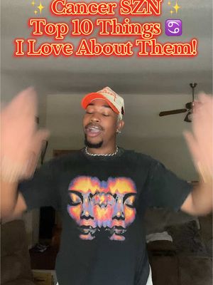 A man with a white and orange cap and a graphic t-shirt is in a home setting, presumably indoors. Overlay text across the top in a gradient includes the words: Cancer SZN, Top 10 Things, and I Love About Them. He is smiling with his arms raised, and the background is slightly blurred. At the bottom of the frame, a ceiling fan is visible.