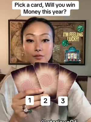 A woman with long dark hair is holding three tarot cards in front of her, with numbers 1, 2, and 3 below them. Above her head, text asks, 'Pick a card, Will you win Money this year?'. In the background are dice and a casino-style slot machine graphic with 'I'M FEELING LUCKY!'