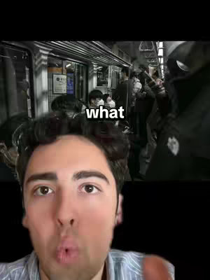 A man is shown from the chest up, his mouth is puckered, and behind him, in a blurred background, is a crowded subway train with people wearing masks.