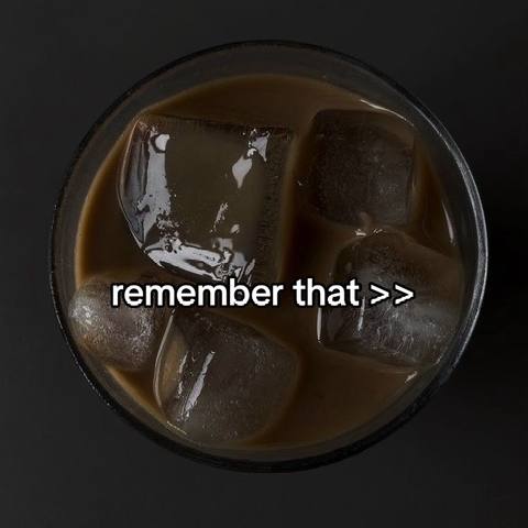 An overhead shot of a glass filled with a brown liquid and ice cubes against a dark background. The text overlay reads: "remember that >>".