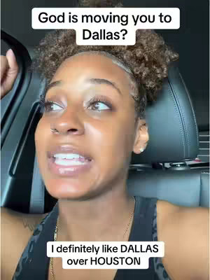 A selfie video featuring a young Black woman sitting in a car, looking towards her right with a slight smile. The top text reads, 'God is moving you to Dallas?' The image is well-lit, showing the woman's face and part of the car interior.