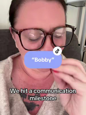 A close-up of a person wearing glasses. The hook "Bobby" is highlighted in a light purple rounded rectangle in the middle of the frame. The person's eyes are mostly closed. Text "We hit a communication milestone" is at the bottom of the frame.