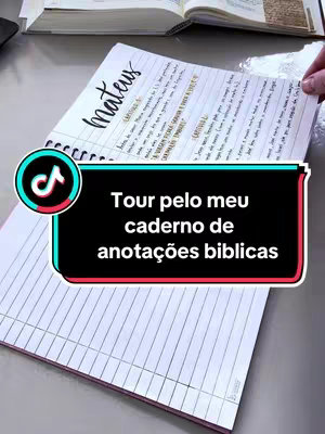 The cover image shows a notebook open on a table. The left side displays a pink lined paper, while the right side reveals written notes about the Bible with the heading 'Mateus' (Matthew). The TikTok logo is present in the foreground. A hand is holding the top corner of the notebook. The background is blurred.
