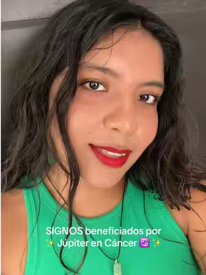 A woman with dark hair, red lipstick, and a green top smiles at the camera. Text overlaid at the bottom reads, 'SIGNOS beneficiados por Júpiter en Cáncer'.