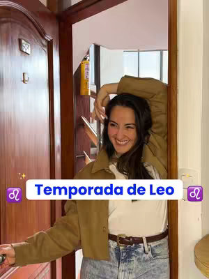 A woman opens a wooden door with a bright smile, her arm resting gently over her head. Overlayed text describes the zodiac sign of Leo.
