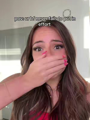 The cover image features a young woman with long, brown hair, appearing surprised with her hand covering her mouth. Her eyes are wide, and her pink nail polish stands out. Text overlayed on the image reads "pov: ur bf never fails to put in effort". The overall composition is a close-up shot with a shallow depth of field, focusing on her face and expression.