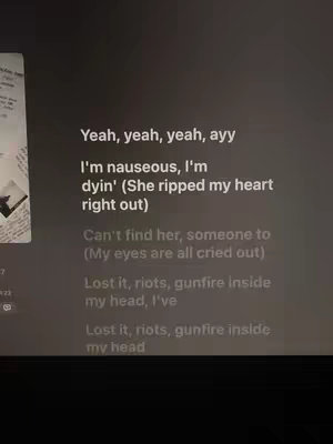 The cover image displays song lyrics overlaid on a dark background. The lyrics, written in a white font, are formatted in a way that may represent the rhythm or flow of the song. The background seems to be another app or device interface, the overall composition is minimal, focusing on the words with a hint of a visual element in the background. The overall color scheme is a mix of white and dark-grey.
