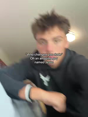 A person, presumably the creator, is shown from a close-up perspective. The background is blurred. The person is wearing a dark hoodie, and the cover image has an added text overlay.
