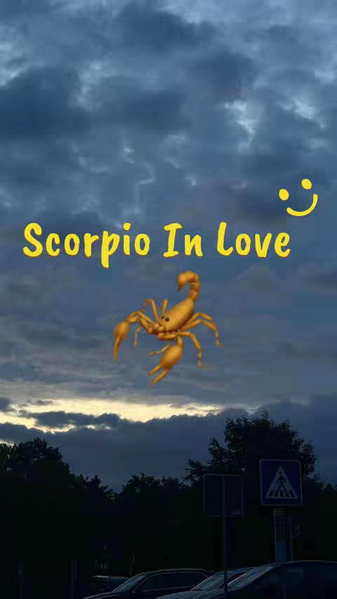 The image is vertically oriented with a backdrop of a cloudy sky transitioning from a darker hue at the top to a lighter glow near the horizon. Positioned centrally is a golden scorpion illustration with the text "Scorpio In Love" in a bold yellow font above it, accompanied by a smiling face emoji on the top right. The bottom silhouette of some trees and parked vehicles adds earthly features.