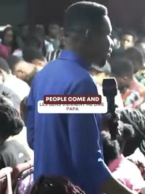 The cover image features a man in a blue shirt speaking into a microphone in front of a crowd. The image is somewhat grainy, and the focus is on the speaker. The background is filled with people, creating a sense of a large gathering.