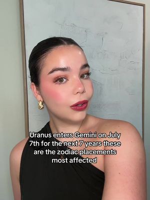 The cover image features a well-lit, close-up shot of a woman. She has dark hair pulled back, adorned with gold earrings. Her make-up includes a bold red lip, pink blush, and eye shadow. The background is an off-white wall with a textured pattern. Overlayed text is present on the bottom.