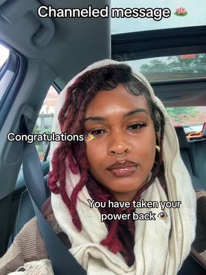 A selfie is taken from inside a car, featuring a woman with dark skin and dark locs, wrapped in a cream-colored scarf, and wearing a nose ring. Text overlays say 'Channeled message', 'Congratulations', and 'You have taken your power back'. The background is blurred.